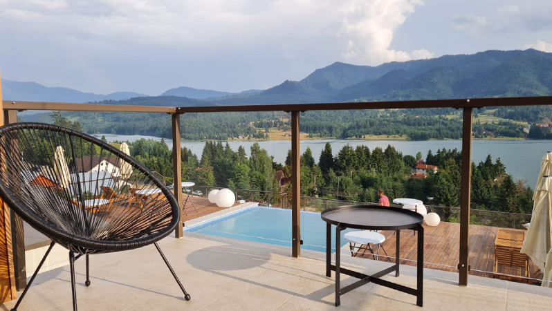 Дізнайтеся більше про співпрацю JYSK B2B з Panoramic Відкрита тераса з комфортним лаунж-кріслом від JYSK з видом на гори та озеро