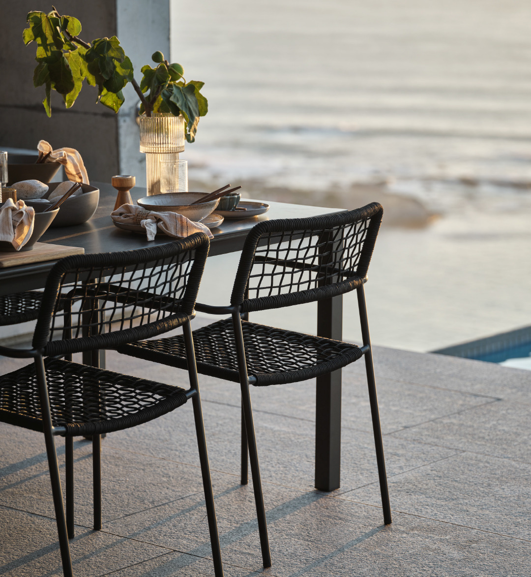 Чорний садовий стілець LABING - ідеальний вибір для вашої тераси, особливо на заході сонця. 